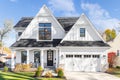 A white modern farmhouse with a black roof.