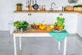 White modern kitchen with colorful vegetables on the wooden table Royalty Free Stock Photo