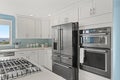 White modern kitchen interior with black refrigerator Royalty Free Stock Photo