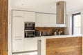 White modern kitchen interior with silver cooker hood above wood