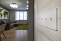 white modern light switch on a white wall on the background of the living room. modern design