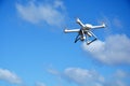 White modern drone with camera flying on sky background Royalty Free Stock Photo