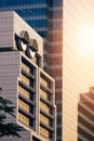 white modern office building with sunlight on glass wall surface of skyscraper in the city at evening time