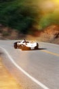 White modern sport car is driving on empty countryside asphalt road at sunset. Royalty Free Stock Photo