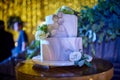 White modern wedding cake over wood table with amber lights