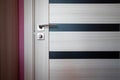 White, modern wooden door , stainless door knob or handle on wooden door in beautiful lighting.