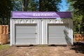 White modular container used as a bar and picnic store with a purple banner