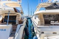 White moored luxury yachts with masts, in contrast to blue calm sea. Reflection of vessels, sky background, close up view Royalty Free Stock Photo