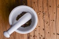 White mortar and pestle with pepper and spices mix on rustic wooden table. Royalty Free Stock Photo