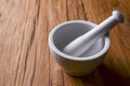 White mortar and pestle with pepper and spices mix on rustic wooden table. Royalty Free Stock Photo