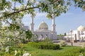 White mosque of the Bulgarians on a sunny spring day against the backdrop of blossoming apple tree branchesapple are out