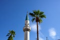 White mosque minaret. Mosque minaret with clouds in the background in Turkey. A tall white tower of a Muslim mosque Royalty Free Stock Photo