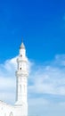 The white mosque tower is set against a beautiful blue sky Royalty Free Stock Photo