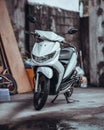 white motorbike parked in front of an open garage door Royalty Free Stock Photo