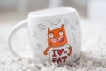 A white mug, a big, a mug with tea, a mug with coffee, bright picture, funny cat