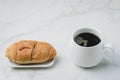 White mug with black coffee and croissant on white stone table. Coffee break Royalty Free Stock Photo