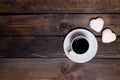 White mug of coffee and two marshmallows in the shape of hearts on a wooden background for breakfast Royalty Free Stock Photo