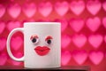 White mug with eyes and red lips on pink and red hearts background Royalty Free Stock Photo