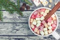 White Mug Of Fresh Hot Cocoa With Marshmallows And Cinnamon Stick On Wooden Background, Christmas Tree And Pine Cones.