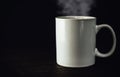 White mug full of hot beverage, a cup of steaming coffee. Royalty Free Stock Photo