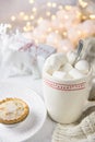 White Mug with Hot Chocolate Cocoa Drink and Marshmallows on Top Mince Pie on Plate. Sparkling Garland Lights Christmas Royalty Free Stock Photo