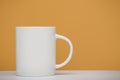 White mug mockup, close-up view, yellow background