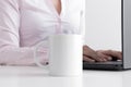 White mug mockup with woman working on a computer Royalty Free Stock Photo