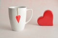 A white mug with a red heart attached to a string Royalty Free Stock Photo