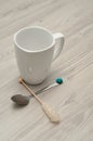 A white mug with a sugar stick and a teaspoon Royalty Free Stock Photo