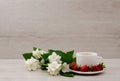 White mug with tea, a branch of jasmine and strawberry Royalty Free Stock Photo