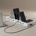 A white multi-device charging station with several smartphones and a tablet vertically docked Royalty Free Stock Photo