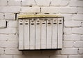 White multi devision mailbox hanging on white brick wall Royalty Free Stock Photo