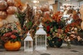 White multi-sized pillar candle lanterns with Christmas decorations in the background