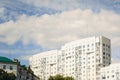 A white multi-storey residential building against the blue sky