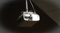 White multimedia projector hanging from a ceiling mount Royalty Free Stock Photo