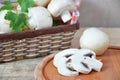 Fresh white mushrooms champignon in brown basket on wooden background. Top view. Copy space Royalty Free Stock Photo