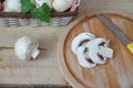Fresh white mushrooms champignon in brown basket on wooden background. Top view. Copy space Royalty Free Stock Photo