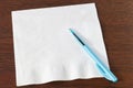 Napkin and Turquoise Biro on Dark Oak Royalty Free Stock Photo