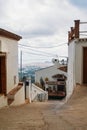 White narrow streets with whitewashed traditional andalusian houses and a view to Mediterranean sea at the horizon at little tour