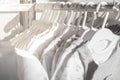 White natural clothes for children hanging on rack in the store. Baby clothes from organic fabrics. Abstract background Royalty Free Stock Photo