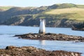 White navigation light beacon on rock