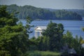 White neoclassical pavilion by the lake surrounded by forest Royalty Free Stock Photo
