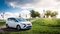 White new family car parked in a green leafy forest. Royalty Free Stock Photo