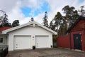 White new garage for two cars and wooden barn on private house yard Royalty Free Stock Photo