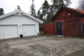 White new garage for two cars and wooden barn on private house yard Royalty Free Stock Photo