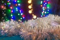 White New Year decor is on the blue table/background close-up. There are different colors lights on the background. Royalty Free Stock Photo