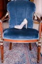 White nice bridal shoes on blue chair.