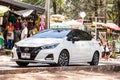 White Nissan Almera on the road near the cafe