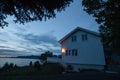 White house on the shore of lake with view to sunset in the Norway at summer Royalty Free Stock Photo