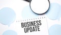 White noteapad and magnifier on blue speech bubles. Text Business Update. Business concept Royalty Free Stock Photo